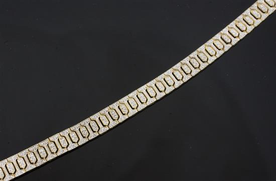 A modern 9ct gold and diamond encrusted bracelet, 7in.